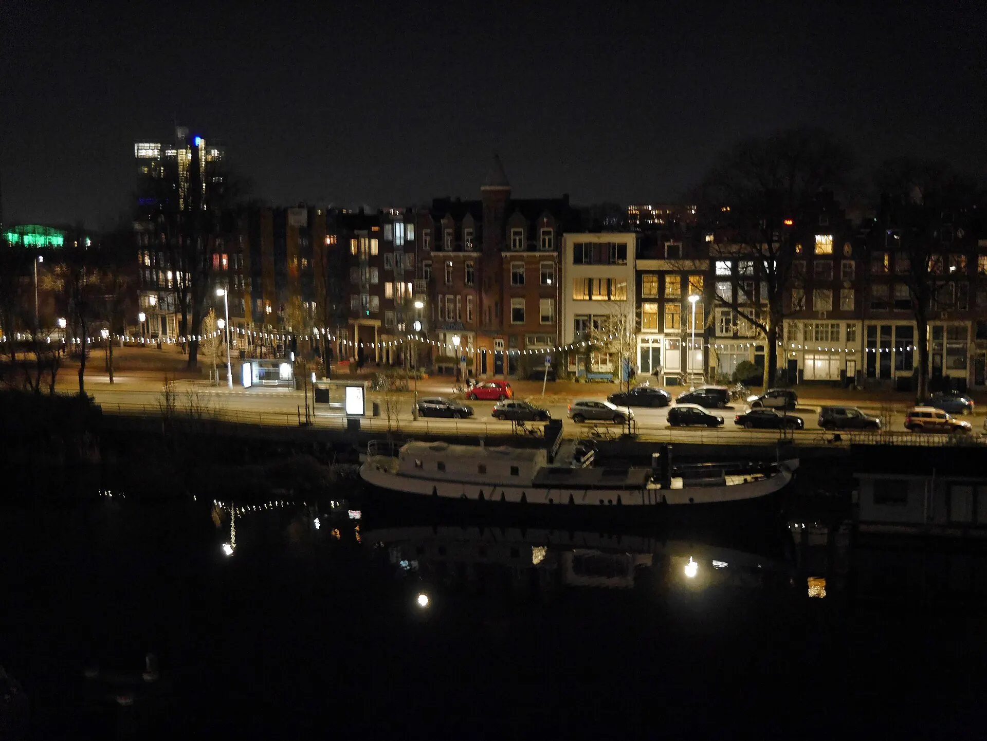 Canal houses along the Kattenburgergracht in Amsterdam at night, a few windows still lit